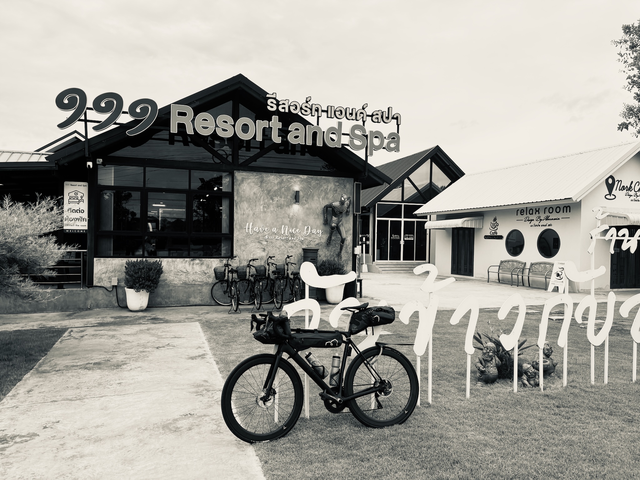A black-and-white roadside resort and spa with a rack of bikes out front