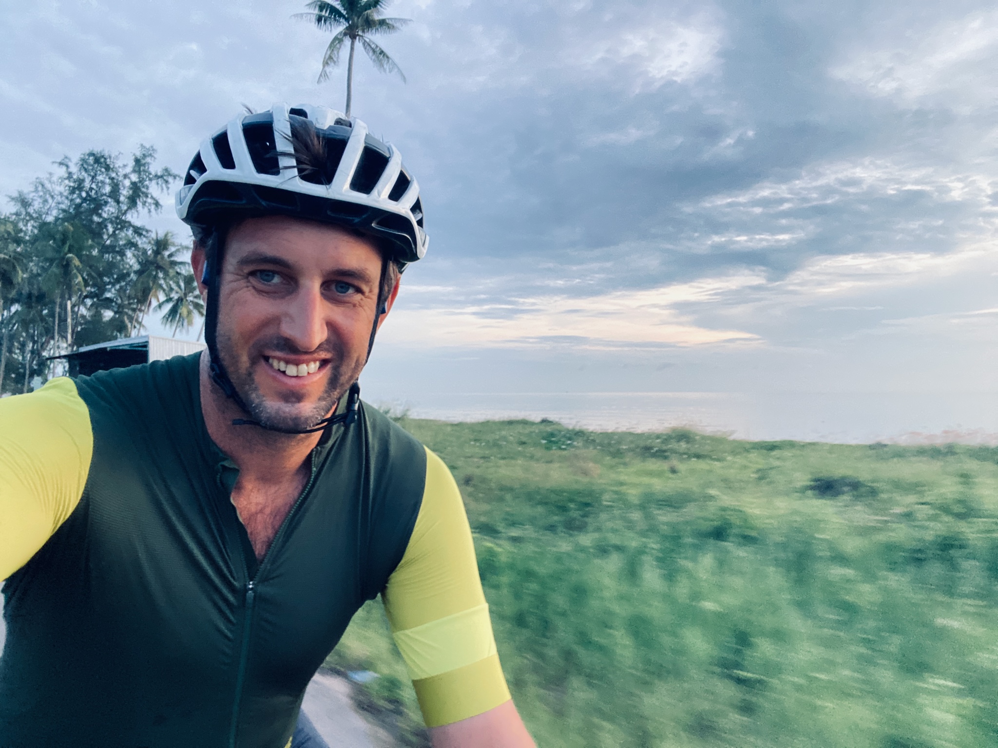 Riding past the sea at dusk, palms behind