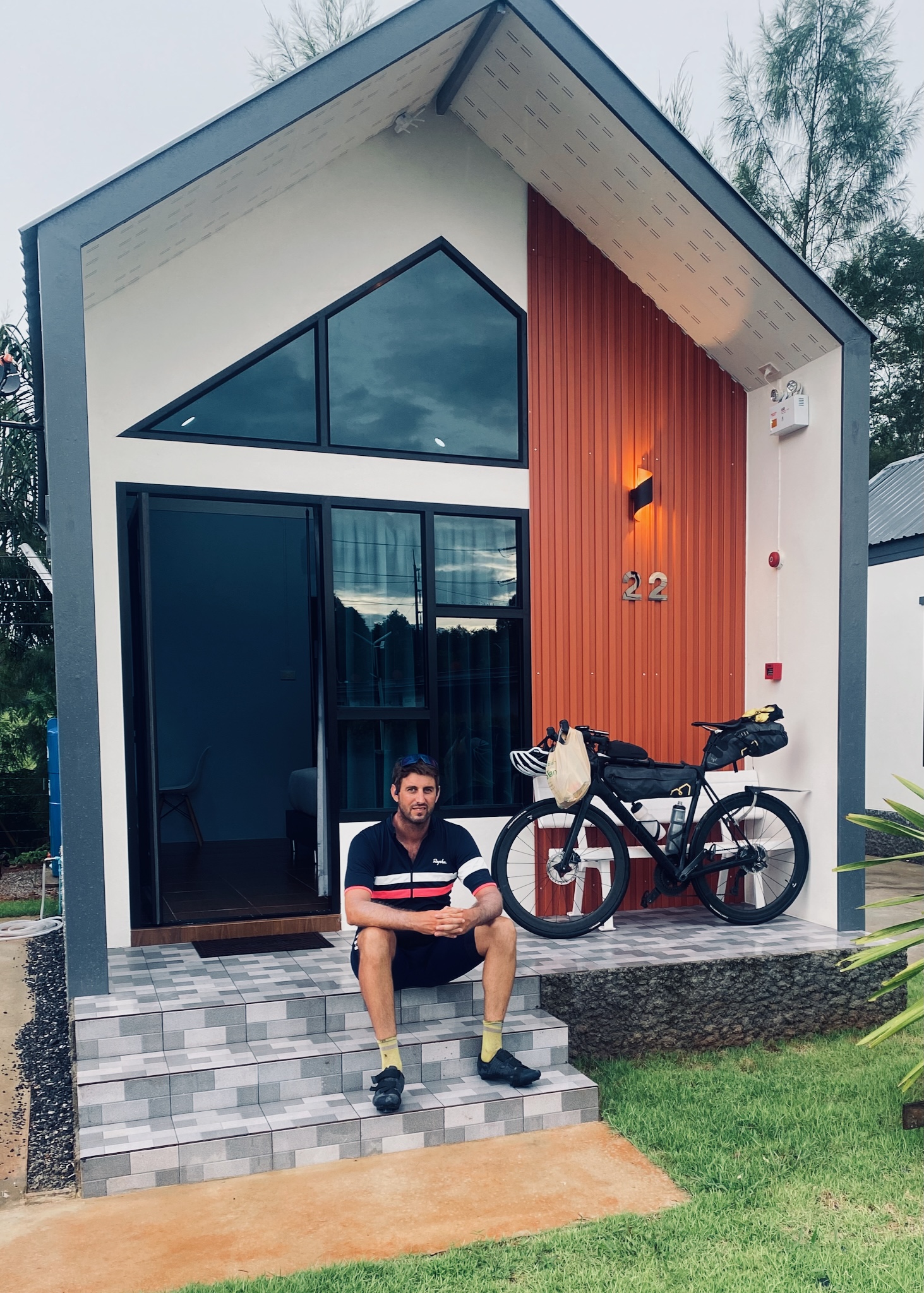 A tiny orange-and-grey cabin, number 22, bike loaded on the porch