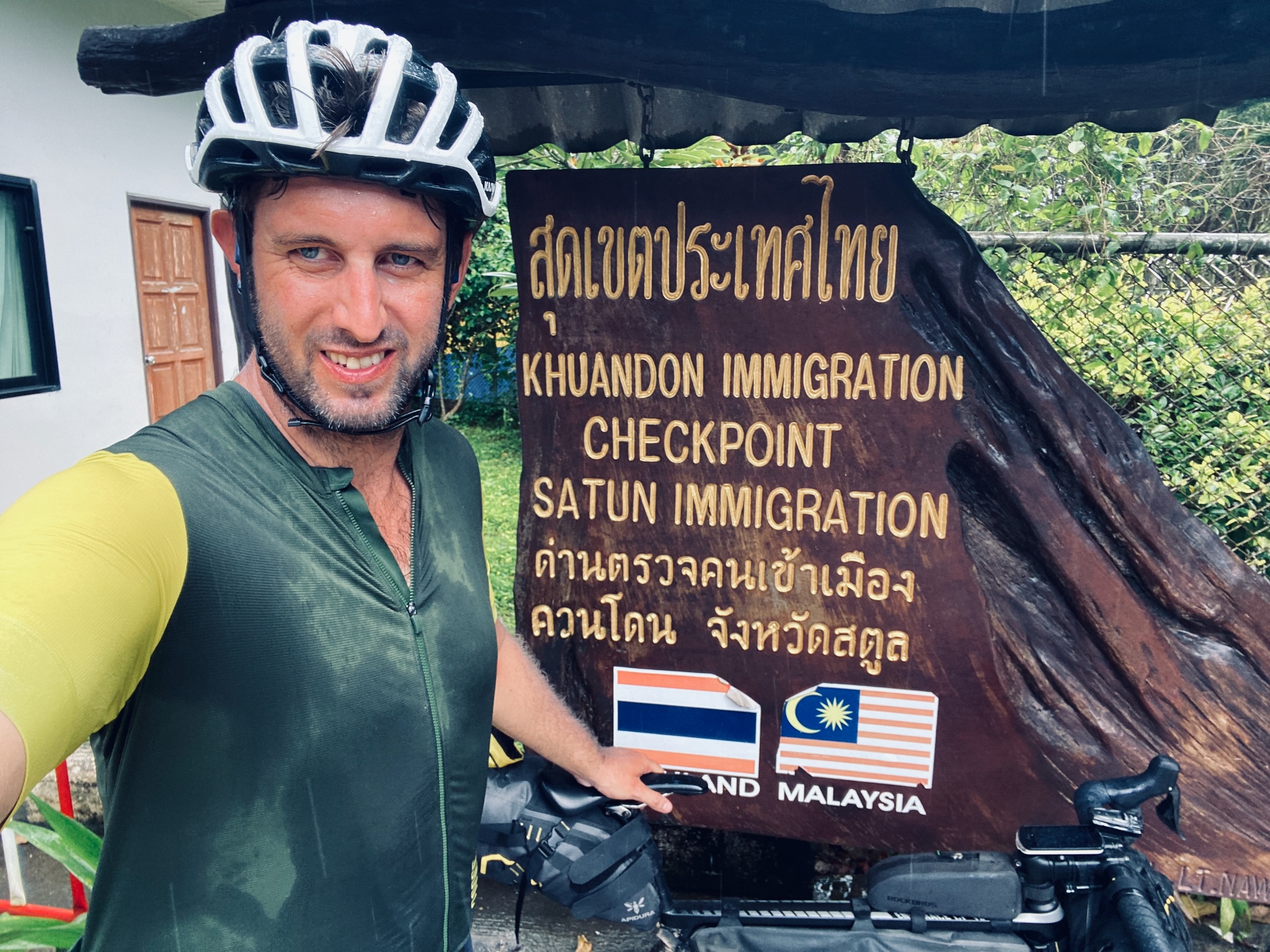 A selfie at the Khuandon immigration checkpoint, Thailand–Malaysia sign behind