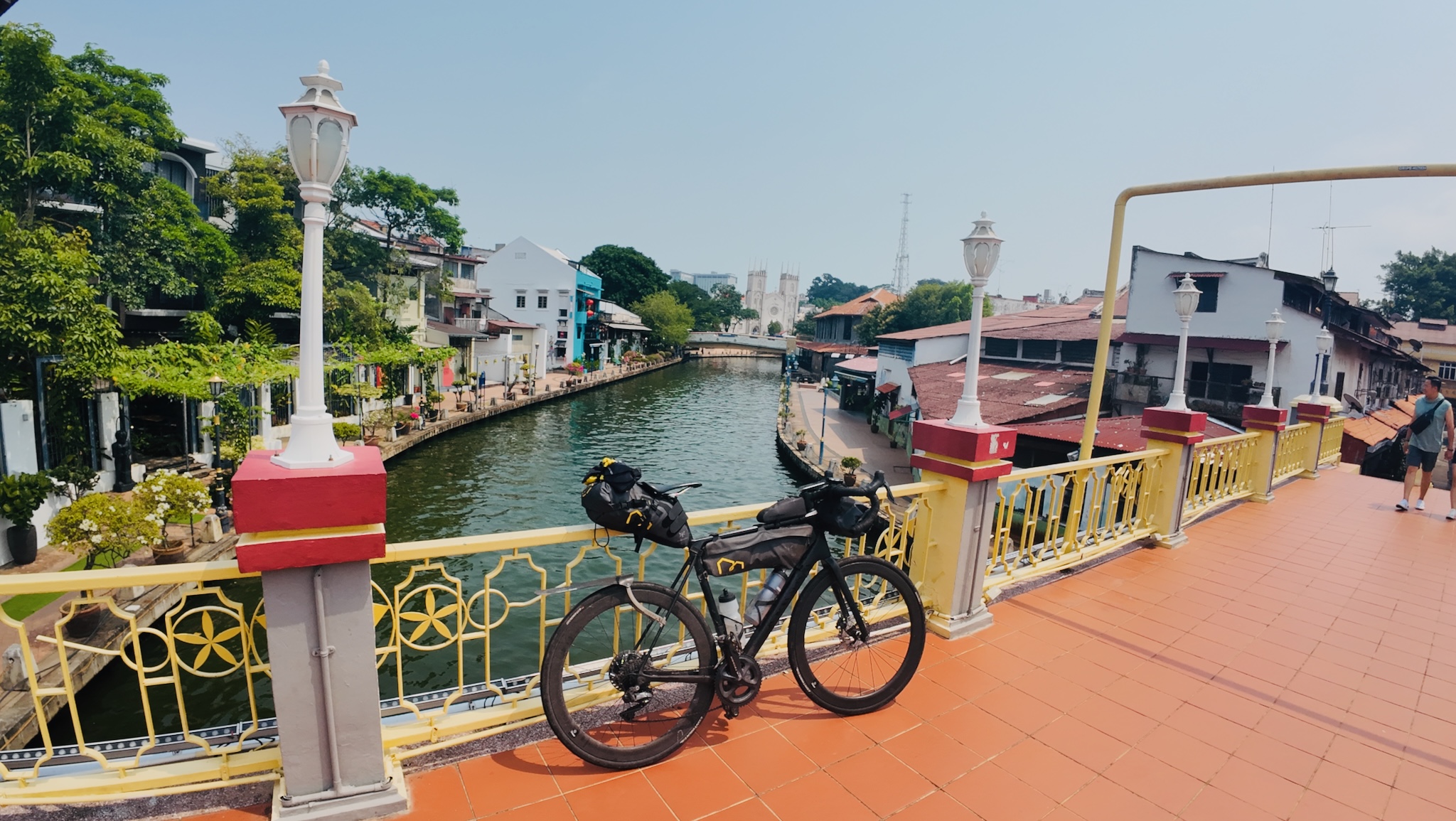 The bike on the ornate red-and-yellow Malacca river bridge
