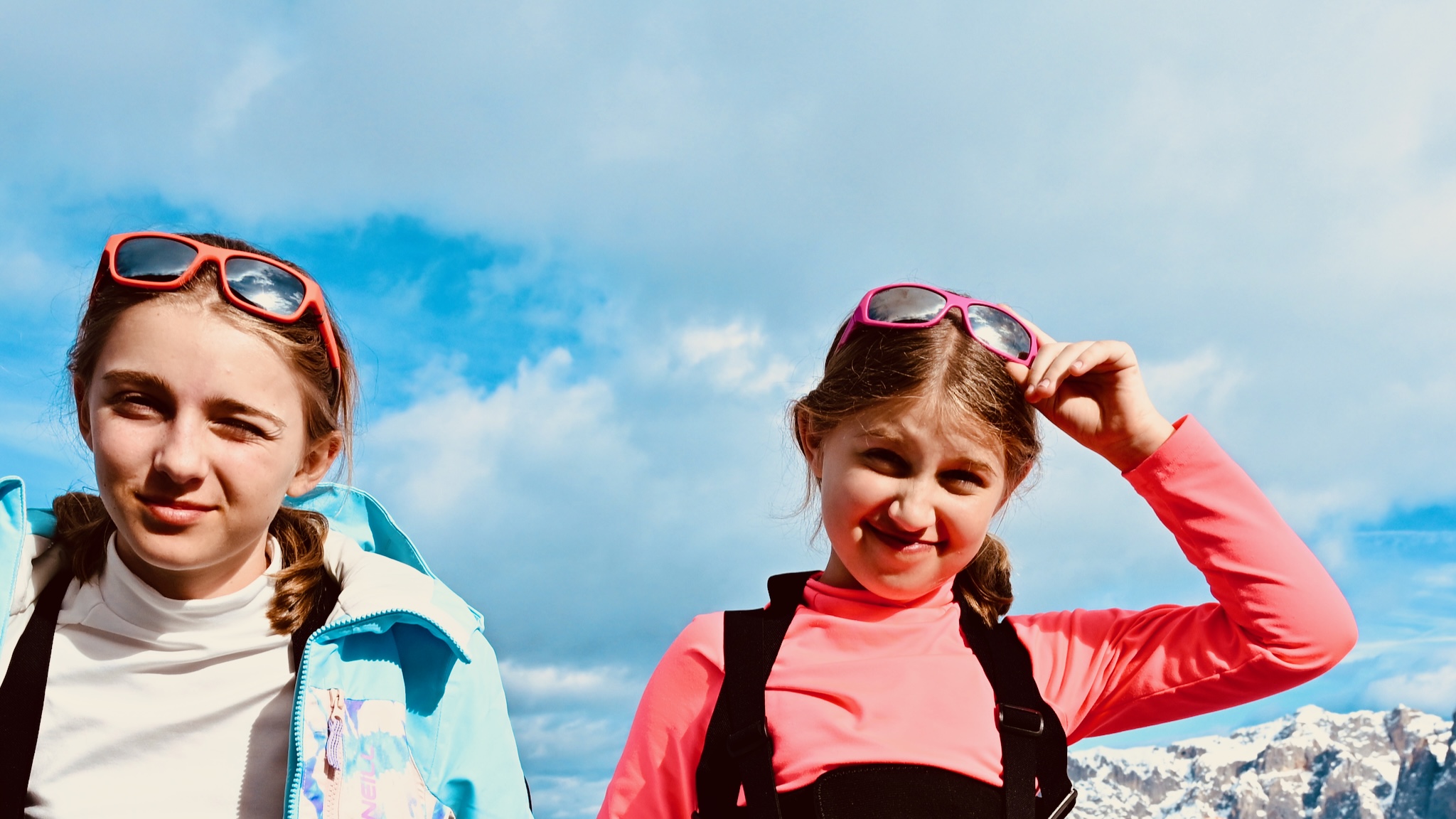 The two girls squinting under a blue sky, black and white