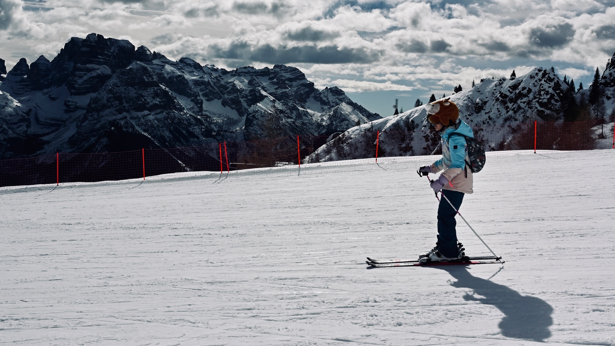A skier crossing below the dark Brenta Dolomites