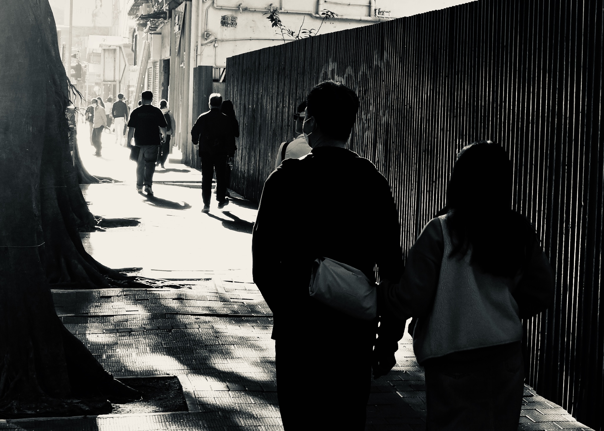 A couple silhouetted in a bright alley, black and white