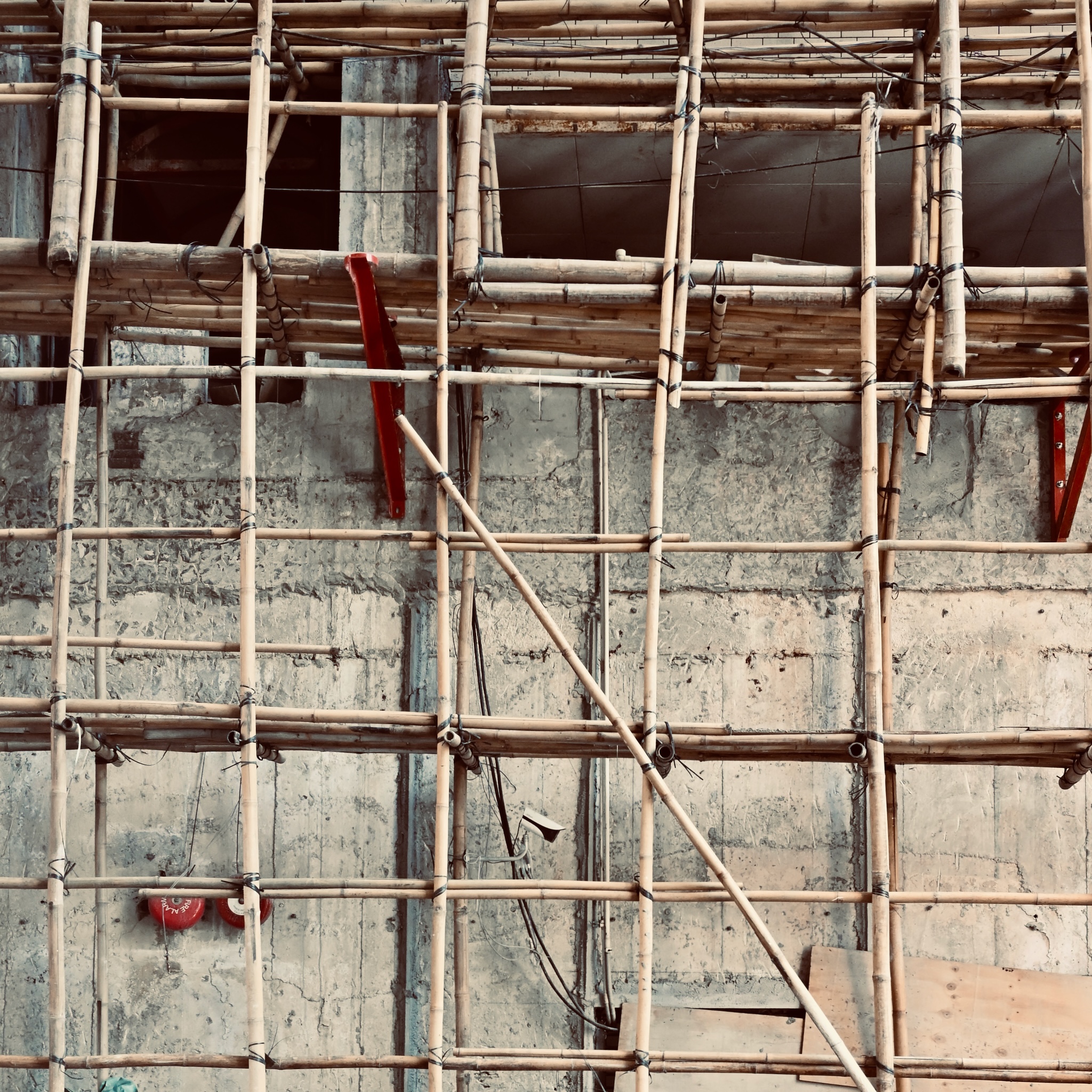 Bamboo scaffolding lashed to a concrete wall