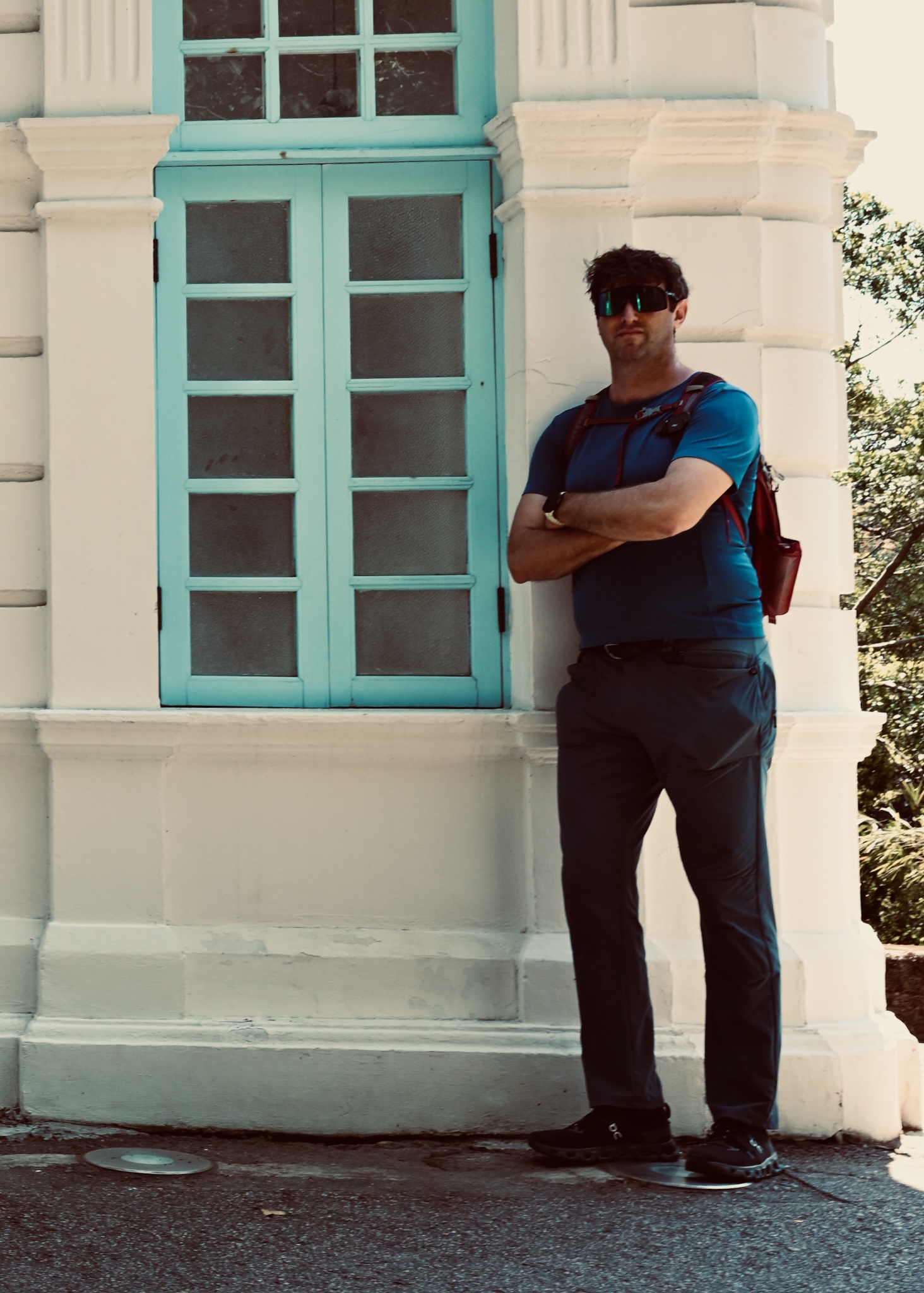Matt leaning against a colonial building with blue shutters