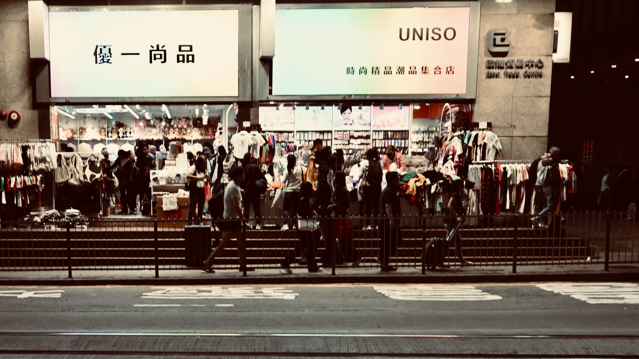 Shoppers outside a brightly lit Uniso store at night