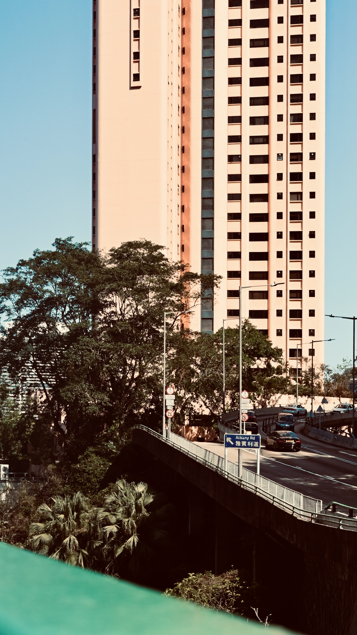 A flyover curving past a pink residential tower