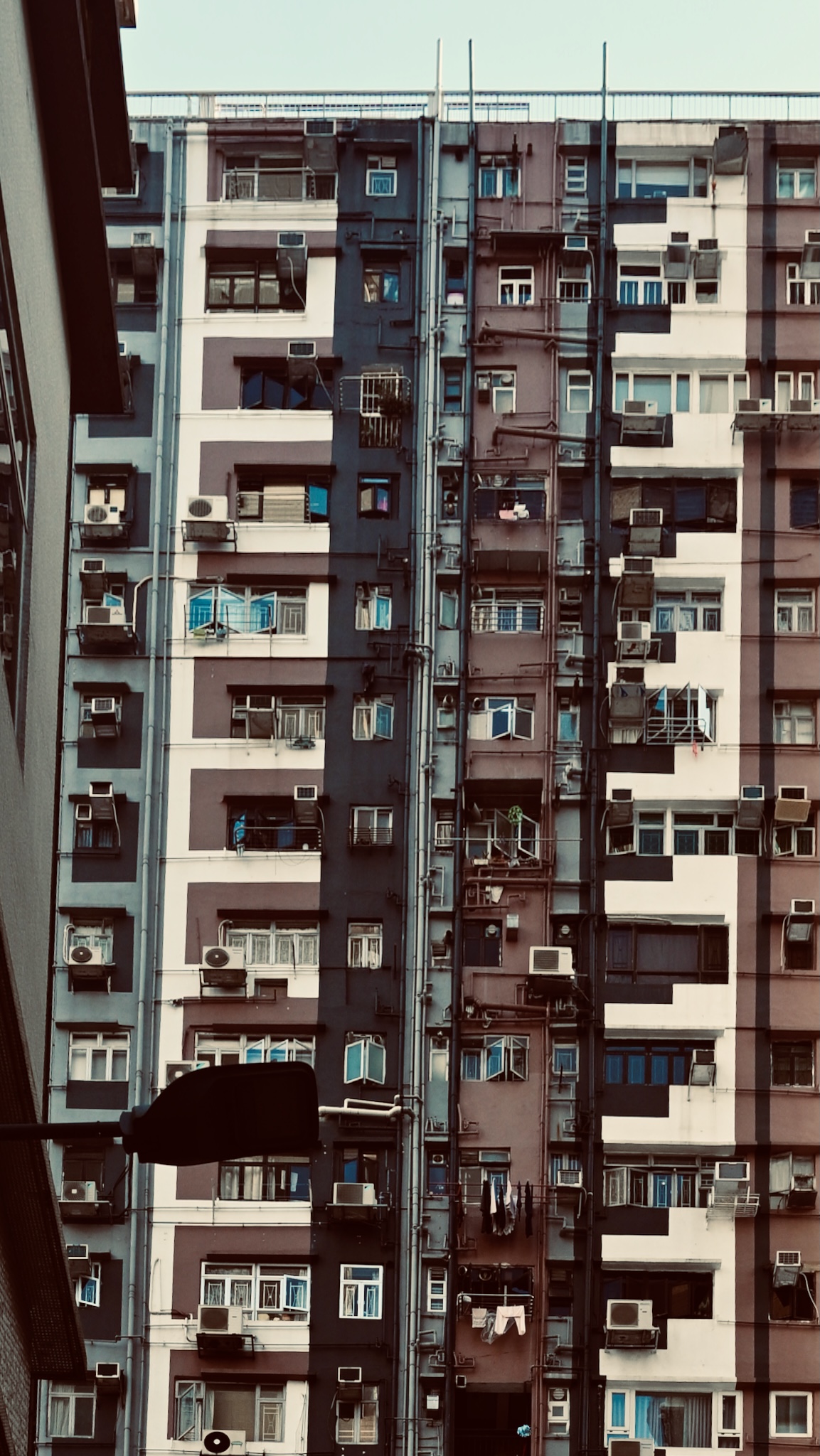 A dense apartment facade packed with air-conditioners