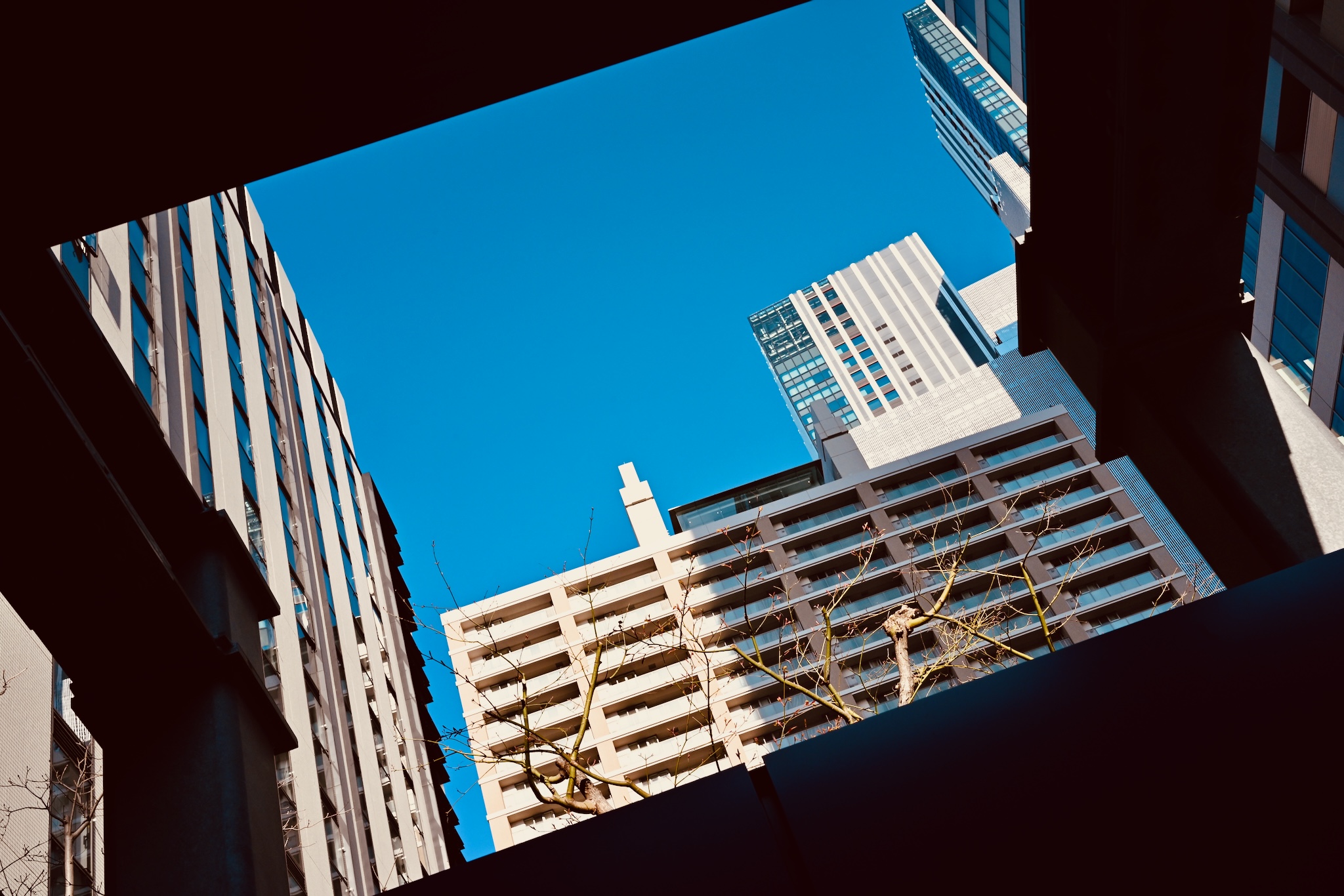 Looking up at Tokyo towers through a gap, blue sky