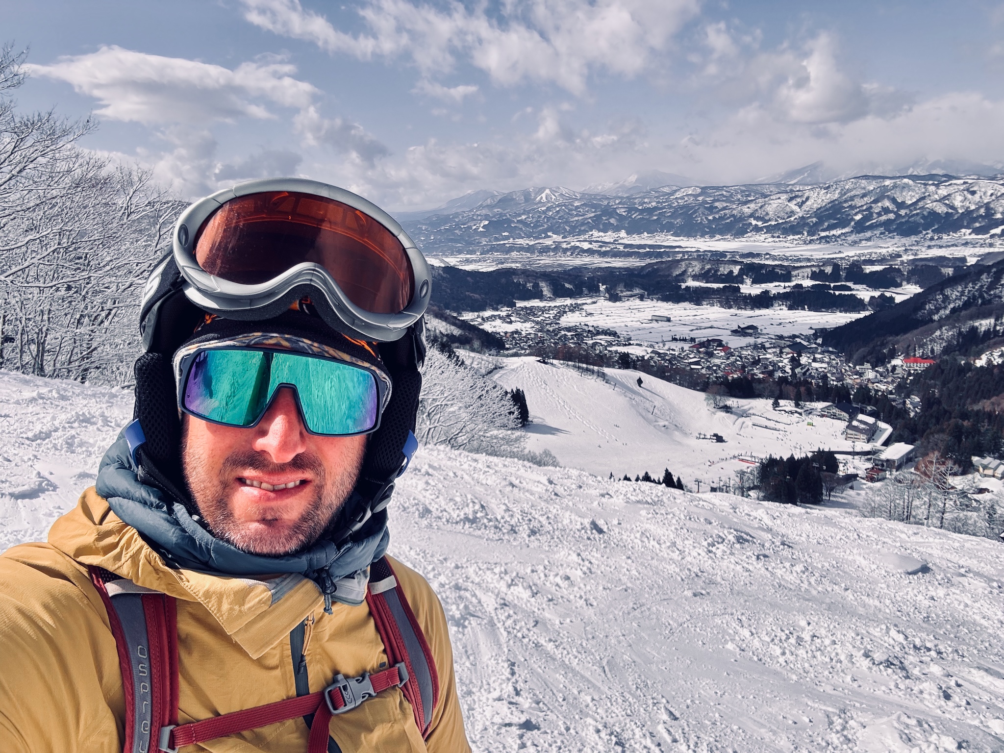 Ski selfie in the sun, the Nozawa valley below