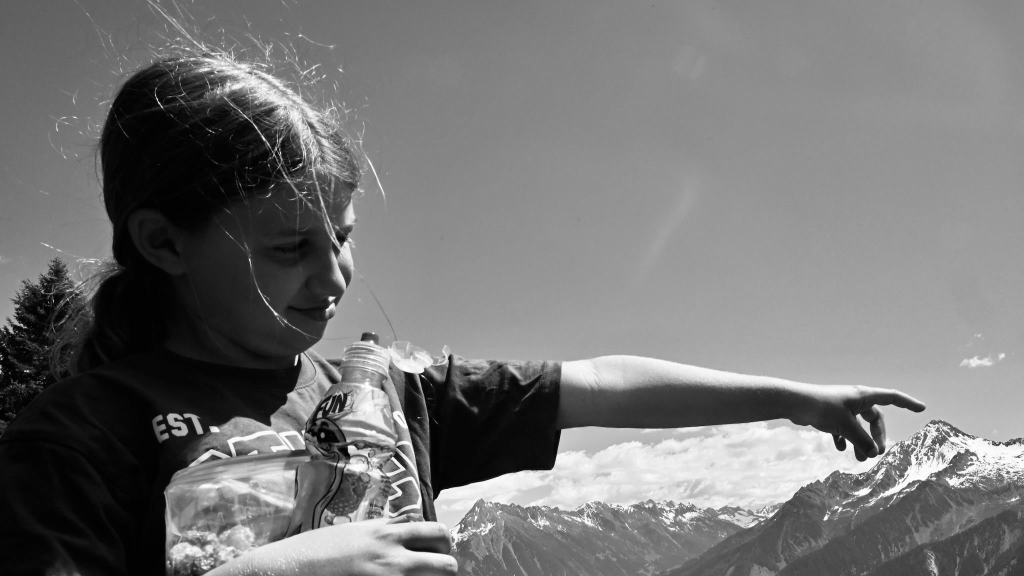 A girl pointing out a peak, black and white