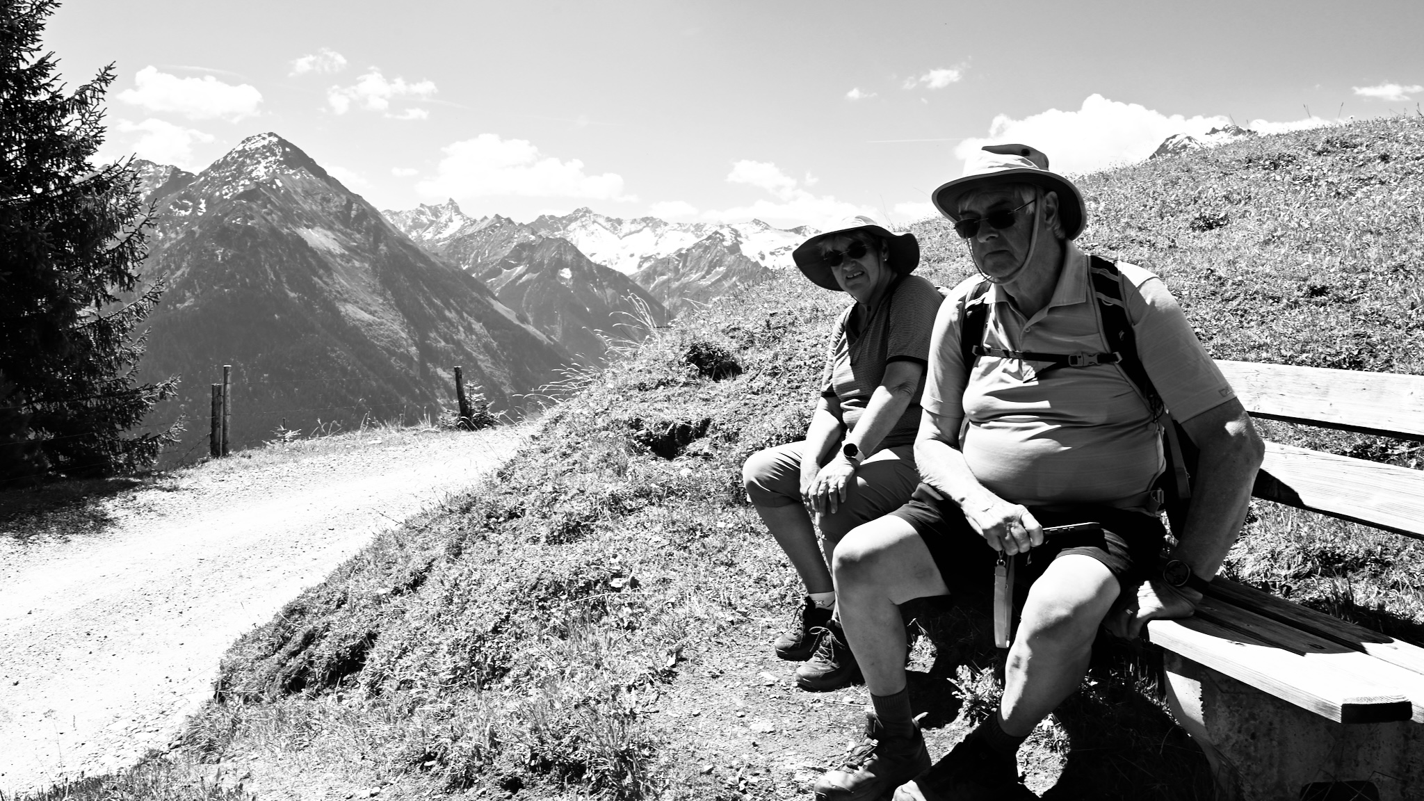 My parents resting on a bench with the mountains behind, black and white