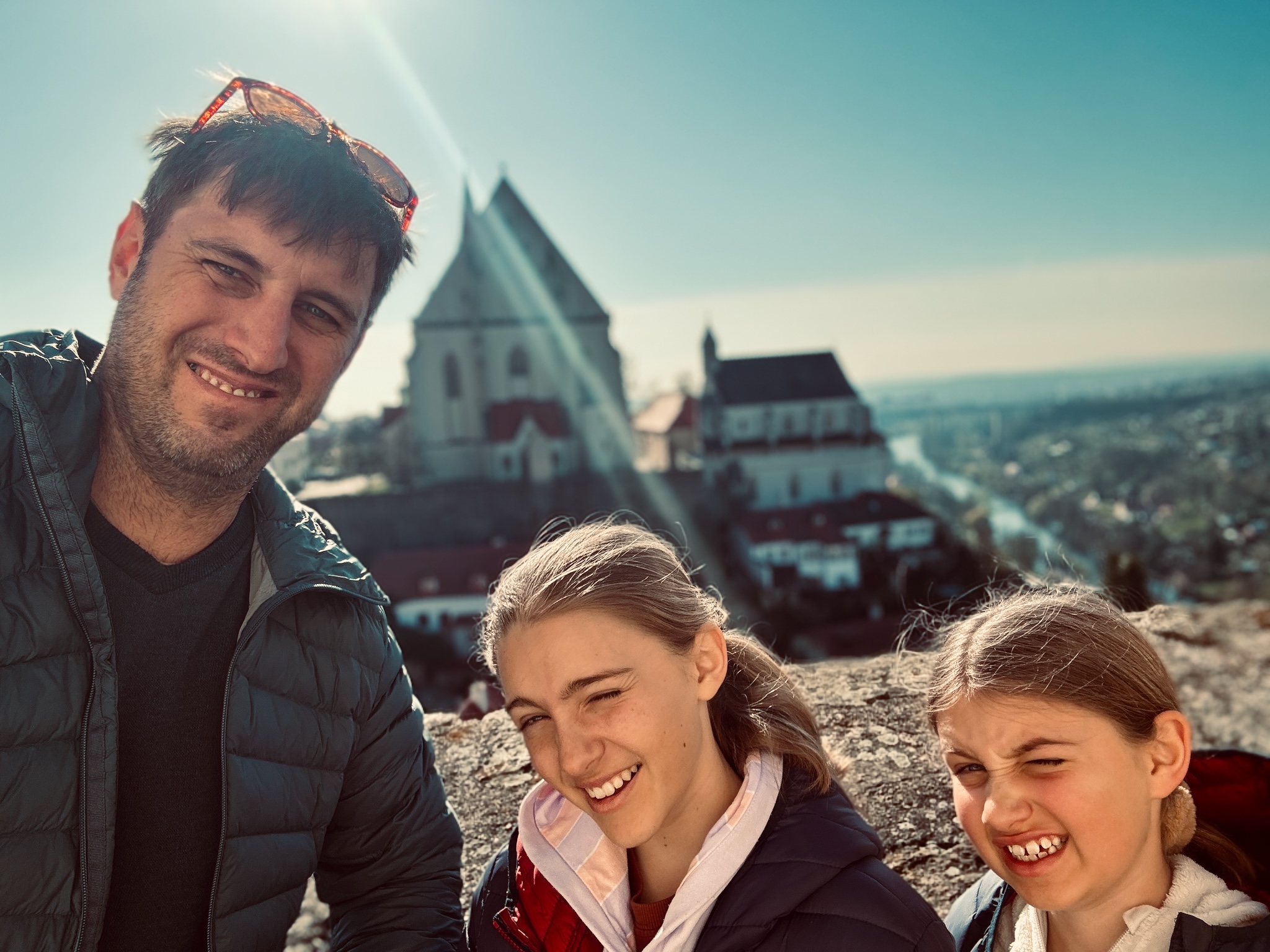 A family selfie with the girls, a hilltop town behind