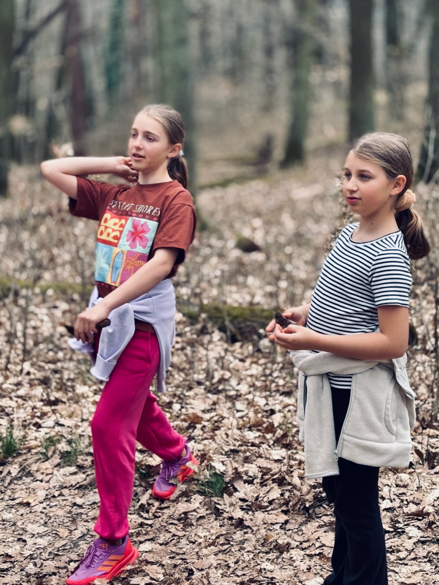 The two girls walking through bare spring woods