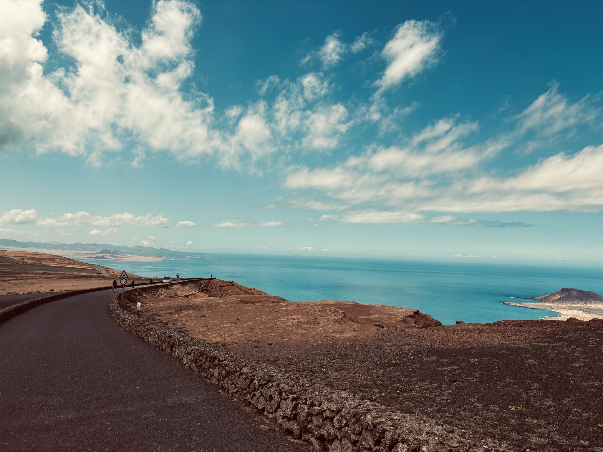 A coast road high above the blue strait, La Graciosa beyond