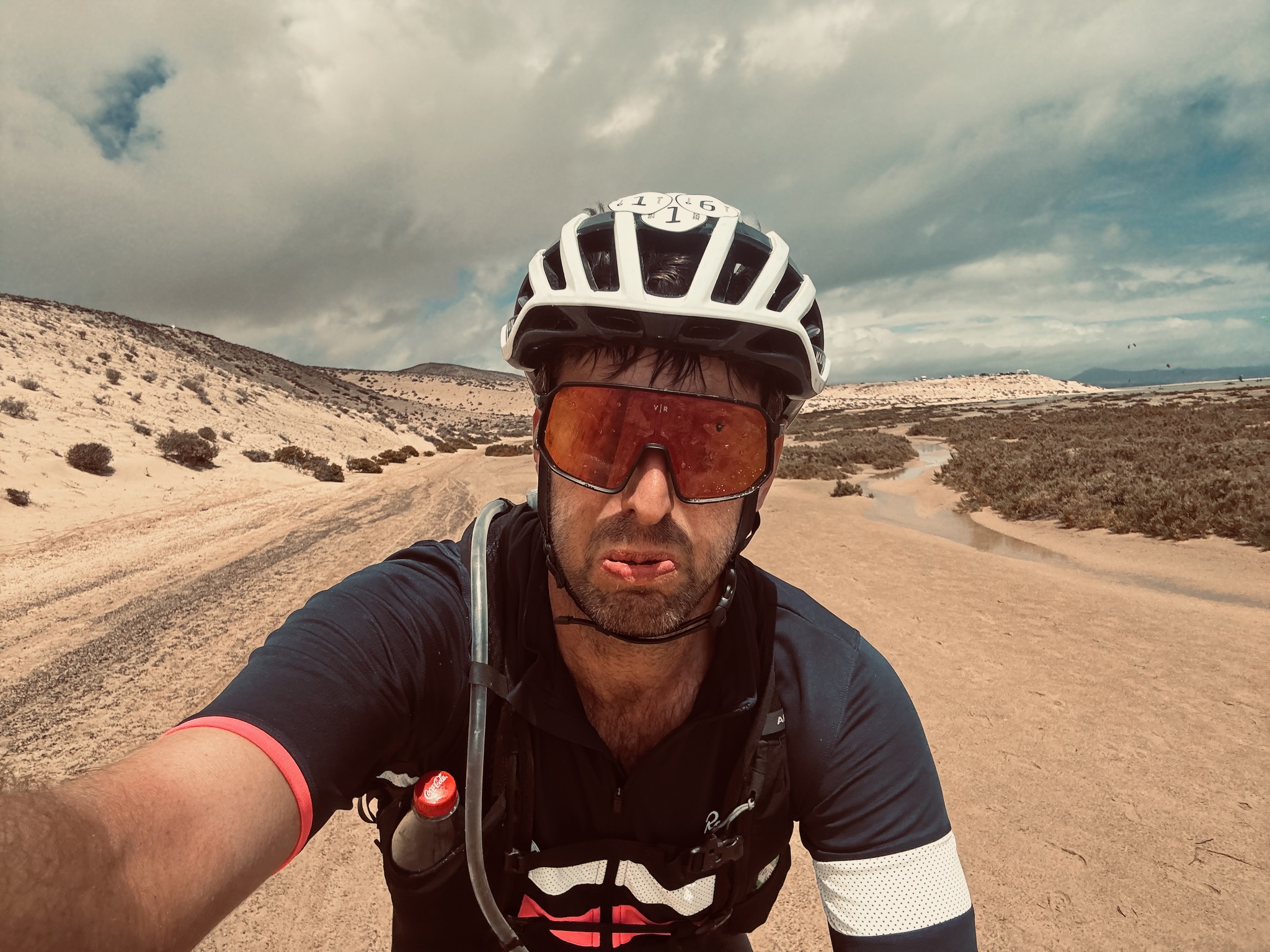 A tired selfie on a sandy track, water pooling across the trail