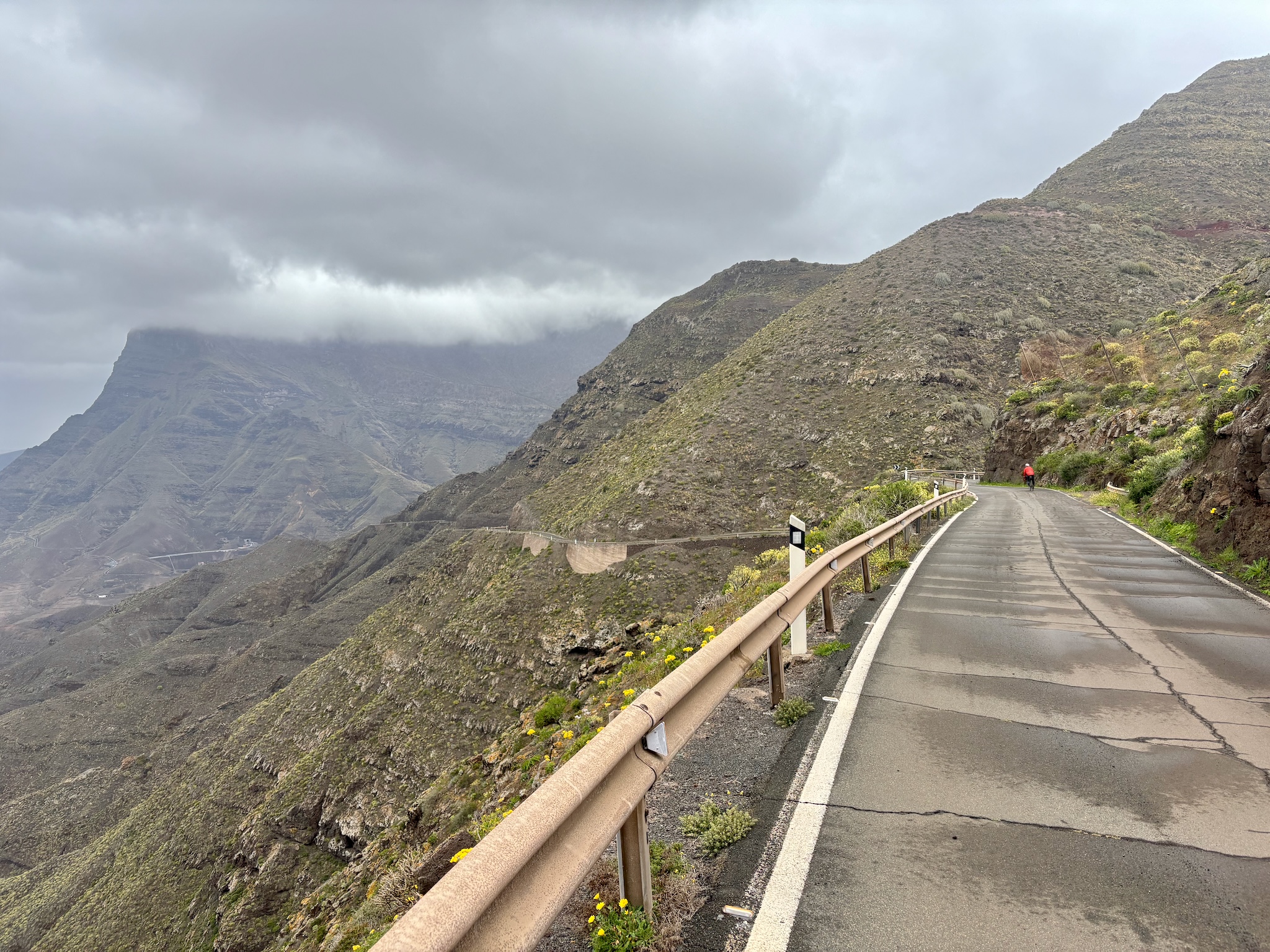 A lone rider on a cliff road wrapped in low cloud, Gran Canaria