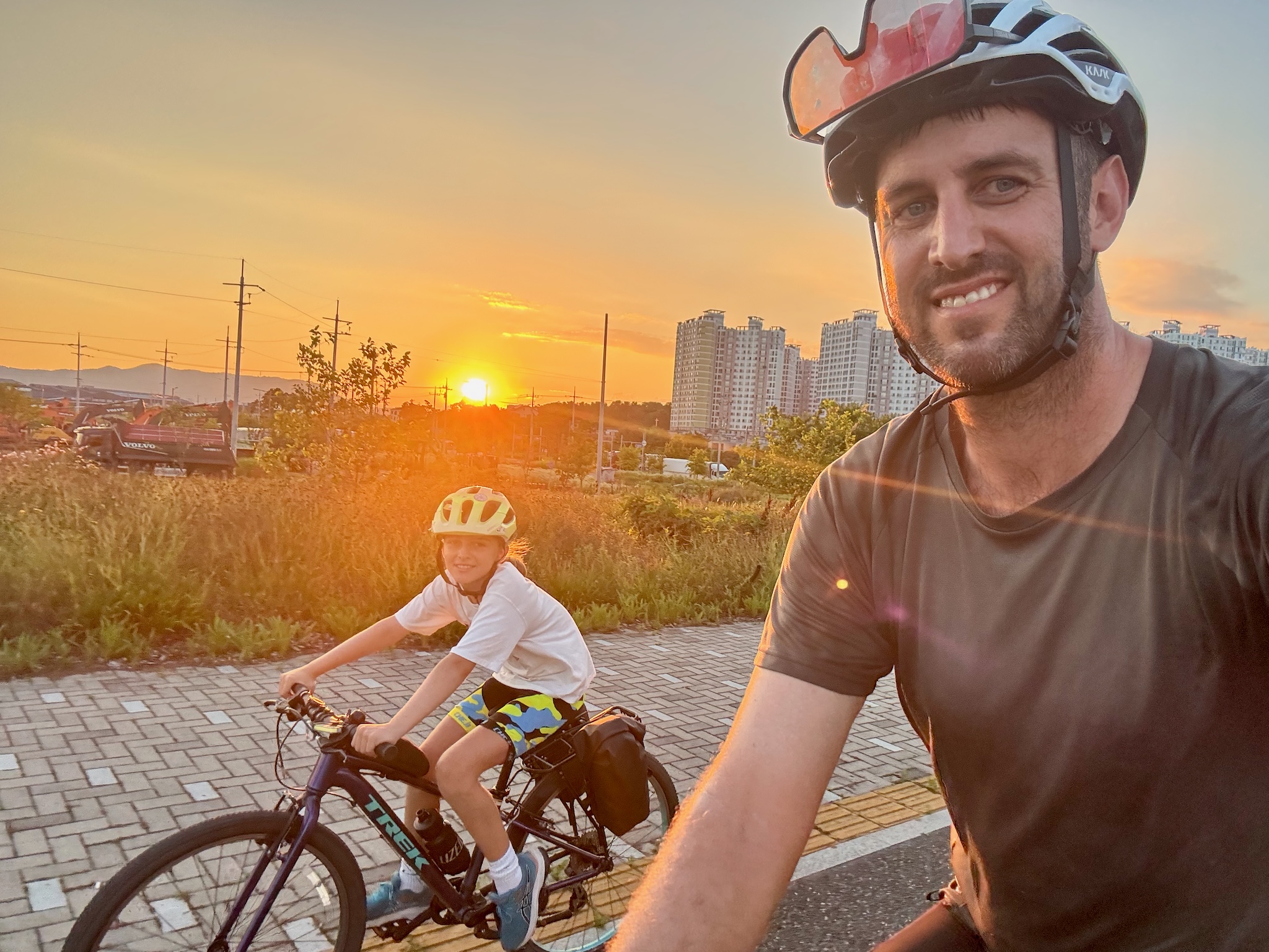 The girls riding at sunset past city apartment blocks