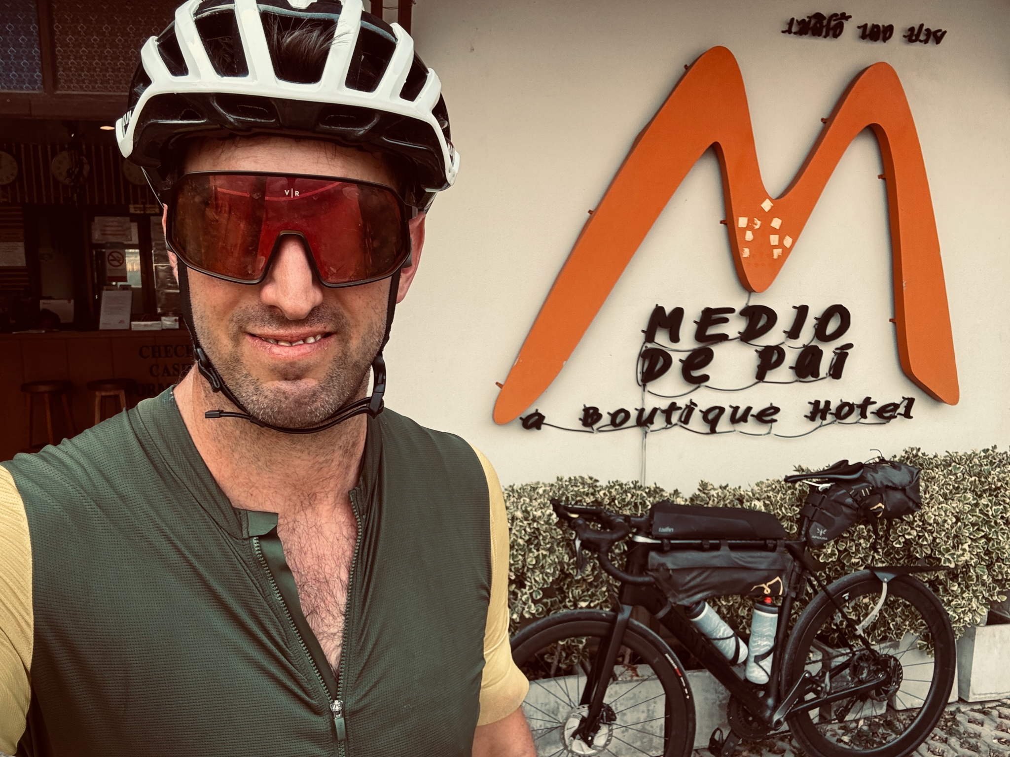 Selfie in front of the Medio de Pai boutique hotel sign, bike alongside