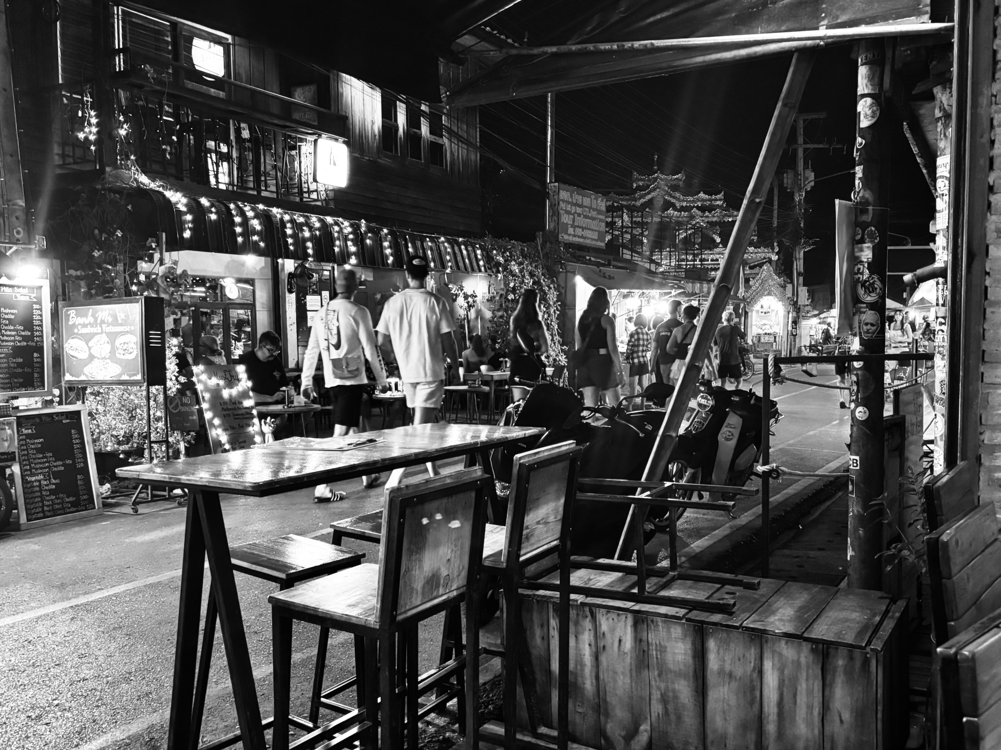 Pai walking street at night, lights and bar tables, in black and white