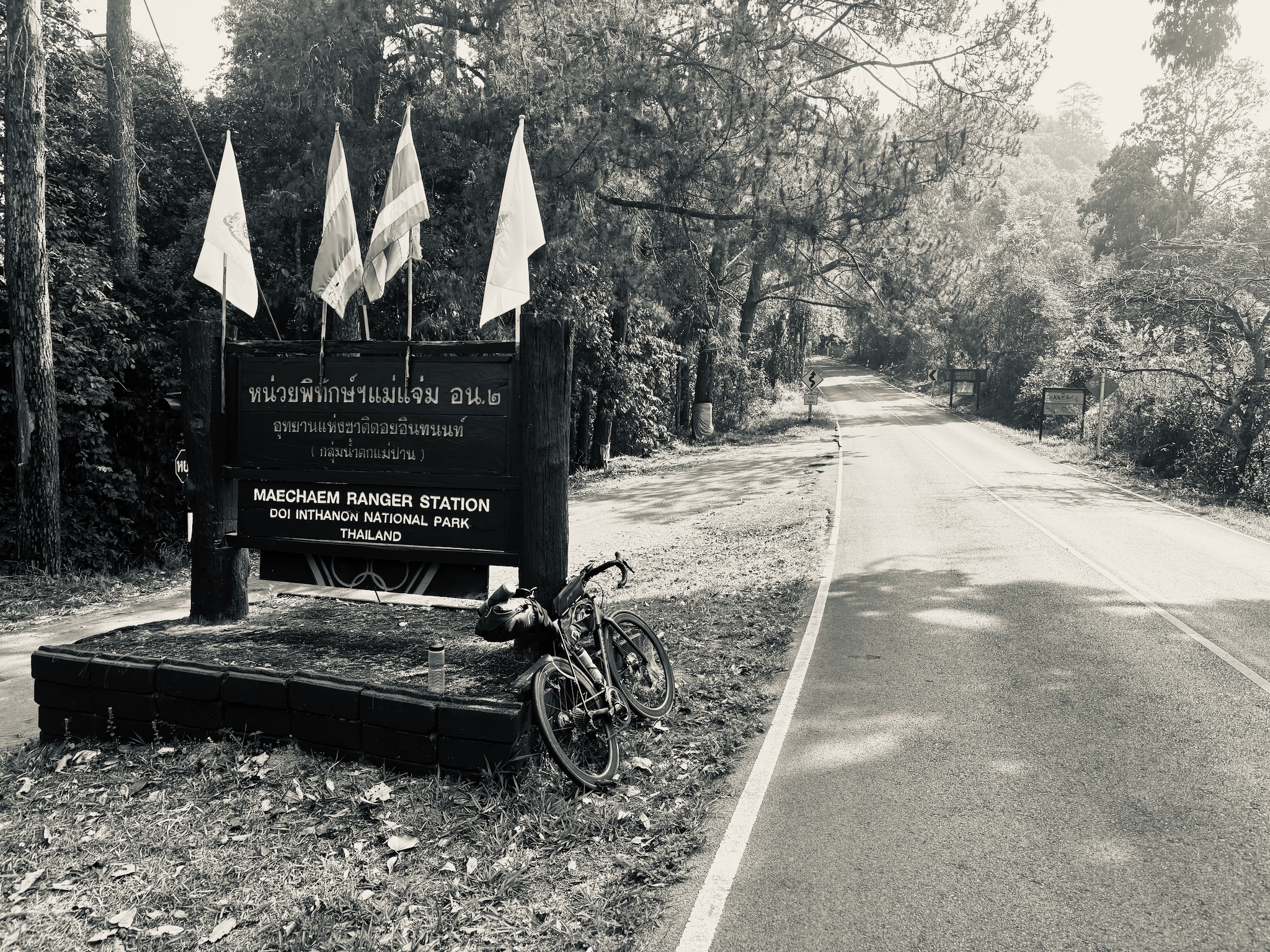 The bike at the Maechaem Ranger Station sign, Doi Inthanon National Park, in black and white